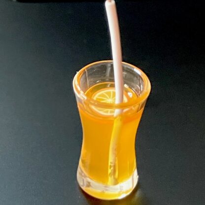 Orangensaft mit Orangenscheibe, Eiswürfeln und Trinkhalm. Glas/Kunstharz.