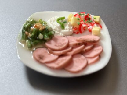 Salate mit Gemüse auf Porzellanteller. Handarbeit.