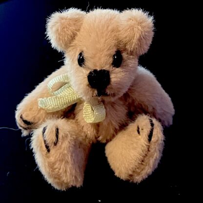 Miniaturteddy (Plüsch, dunkelbeige, grünes Satinband). Handarbeit.